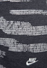 Gray fabric with white horizontal stripes, featuring a textured pattern. Includes a small white Nike logo in the lower corner.