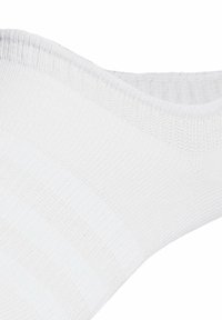 Vita strumpor gjorda av ribbad elastisk material, med en slät yta och ett subtilt rutigt mönster på ytan.