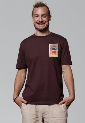 Bordeaux katoenen T-shirt met een bedrukte afbeelding op de linkerborst met een kleurraf grafiek en tekst, korte mouwen en een relaxte pasvorm.
