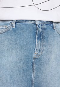 Light blue denim jeans with a faded wash, featuring a traditional waistband, front pockets, and subtle stitching details.