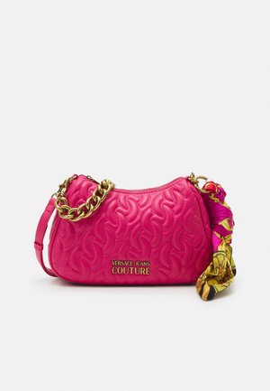 Sac à bandoulière matelassé rose avec bandoulière chaîne dorée et détail foulard multicolore, marqué "Versace Jeans Couture" à l'avant.