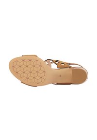 Sandelă din suede bej cu un design perforat, talpă plată cu un model hexagonal și o zonă a degetelor netedă și rotunjită. Mărimea 38 indicată.
