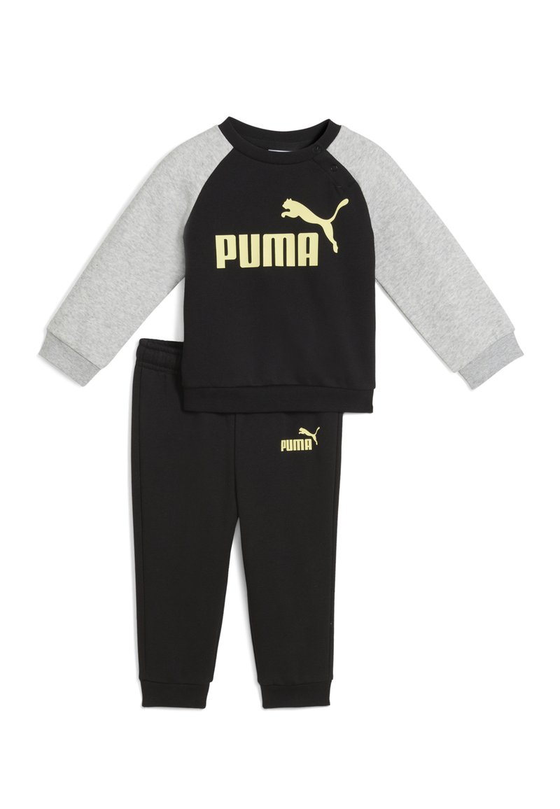 Mustat ja harmaat lasten urheilupuku, joka on valmistettu puuvillasekoitteesta. Vaatteessa on musta pitkähihainen paita, jossa on keltainen "PUMA" -logo, ja yhteensopivat mustat housut.