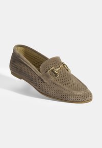 Beige geperforeerde suede instappers met een ronde neuzen, decoratieve gespdetail en een platte rubberen zool. Textuele afwerking en veelzijdig ontwerp.