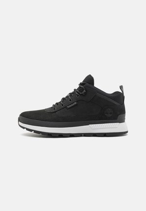 Sneakers negri din suede cu o talpă intermediară albă, având un vârf rotund, un sistem de închidere cu șireturi și accente texturate. Sigla pe călcâi.