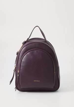Purple leather backpack with a rounded design, featuring gold hardware, dual zippered compartments, and a top handle for easy carrying.
