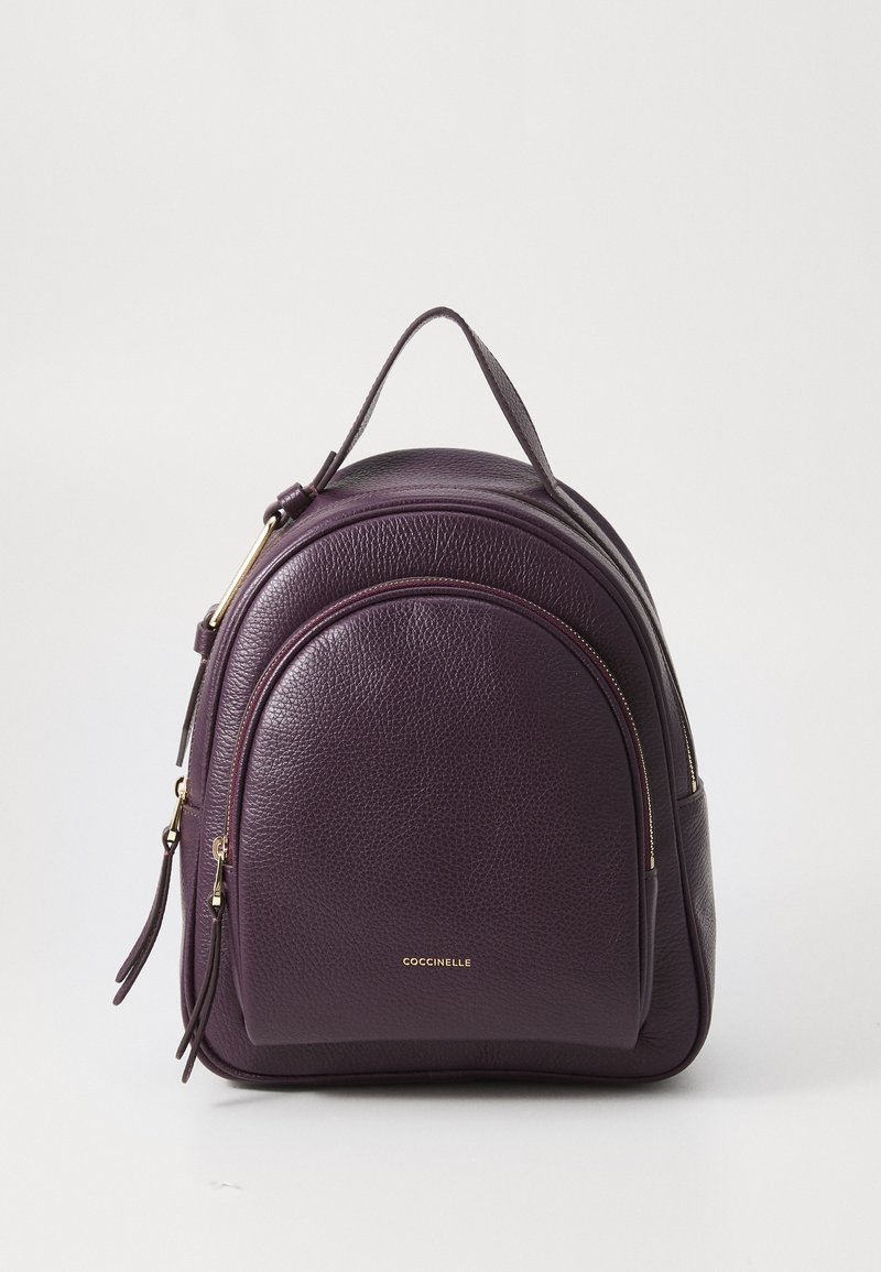 Sac à dos en cuir violet au design arrondi, avec des finitions en or, deux compartiments zippés et une poignée supérieure pour un transport facile.