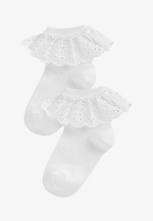 Chaussettes blanches en coton à la cheville avec un bord en dentelle froncée présentant des découpes florales, texture lisse et ouverture élastiquée pour un maintien sécurisé.