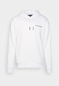 Bílá mikina s kapucí z měkké bavlněné látky, s kapucí na stažení a malým námořnickým logem na levé straně hrudi. Volný střih.