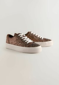 Adidași strălucitori cu accente din suede maro, șireturi albe și o talpă din cauciuc texturată. Caracterizează un finisaj strălucitor de aur rose.