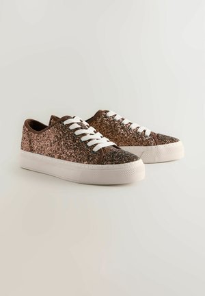 Kimaltavat lenkkarit, joissa on ruskeat samettiset yksityiskohdat, valkoiset nauhat ja teksturoitu kumipohja. Korostaa kimaltelevaa ruusukultaa.