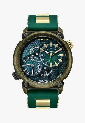 Grüne Silikonarmbanduhr mit einem bronzefarbenen Gehäuse. Sechseckiges, strukturiertes Zifferblatt mit goldenen Akzenten. Verfügt über eine duale Zeitzonendarstellung und Markierungen.