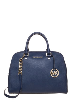 Marineblauwe Michael Kors handtas met dubbele handvatten, een gouden kettingdetail en een ronde MK-logo hanger aan de rechterkant.