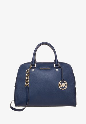 Marineblauwe Michael Kors handtas met dubbele handvatten, een gouden kettingdetail en een ronde MK-logo hanger aan de rechterkant.