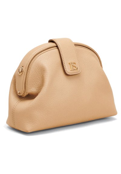 Beige leather handbag with a rounded design, top zip closure, and a decorative flap featuring a gold logo accent. Soft texture and stitched details.