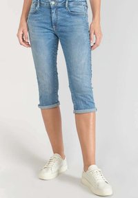 Jeans capri en denim bleu clair avec ourlets roulés, présentant un design classique à cinq poches et une texture légèrement délavée.