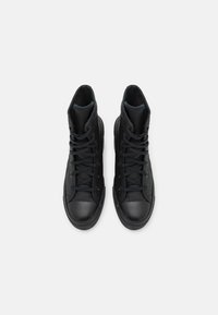 Black high-top sneakers made of textured leather with rubber toe caps, featuring black laces and a padded collar.