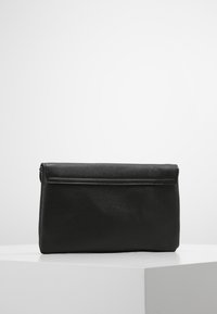 Černá kožená psaníčko s texturovaným povrchem, obdélníkového tvaru a uzavíráním na horní klopu. Minimalistický design bez viditelného kovového kování.