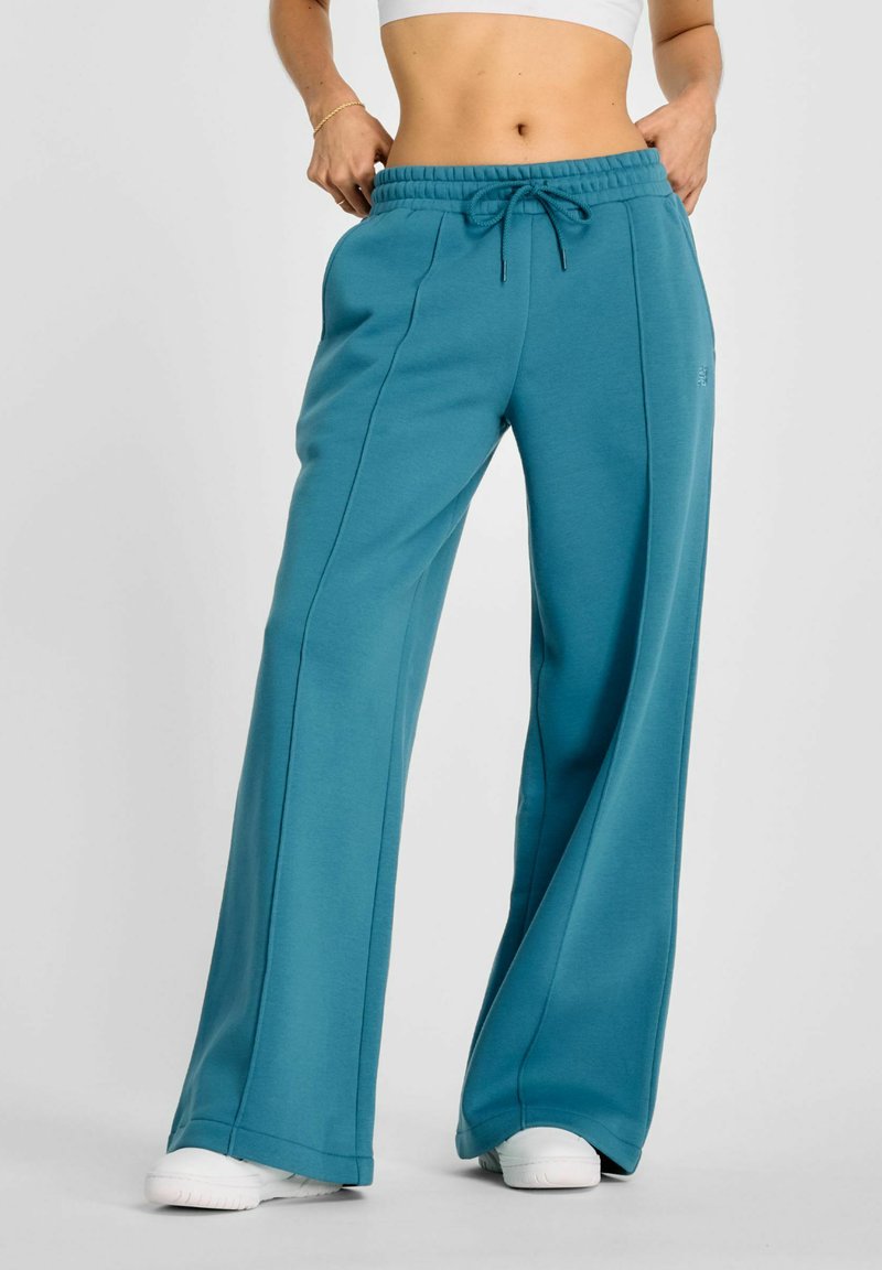 Teal wijde sweatpants gemaakt van zachte stof, met een elastische tailleband met trekkoord, voorkant naden en een relaxte pasvorm.