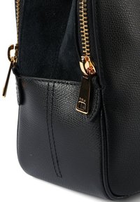 Μαύρη δερμάτινη τσάντα χειρός με υφή, χρυσά φερμουάρ και διακριτικές ραφές. Διαθέτει πλαϊνή τσέπη και κομψό σχεδιασμό.