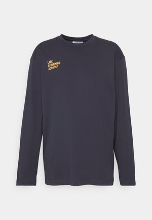 Zwarte longsleeve crewneck shirt met kleine gele tekst "LIFE AFFIRMING ACTIVISM" op de linkerbovenborst.