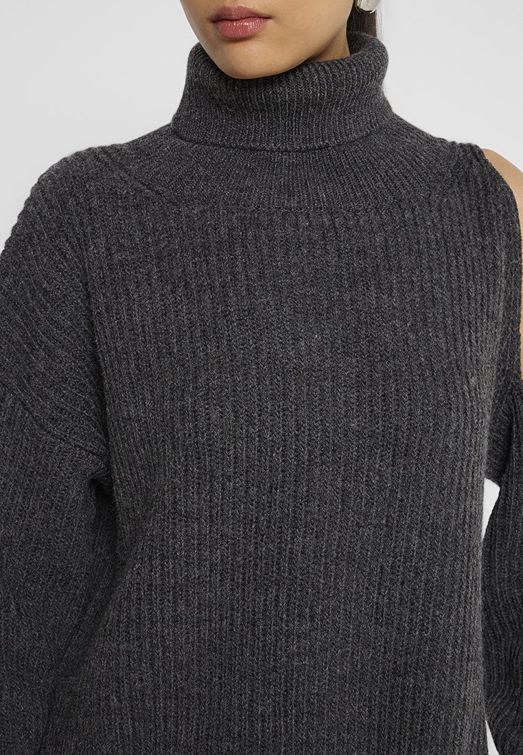 Maglione a collo alto grigio scuro a coste con dettaglio intrecciato su una spalla. Tessuto morbido, maniche lunghe e vestibilità morbida.
