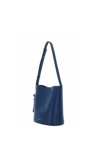 Sac seau en cuir bleu à texture lisse avec une sangle ajustable. Comprend un pompon latéral et un marquage subtil à l'avant.