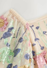 Beige Tüllstoff mit buntem floralem Paillettenstickerei, einschließlich pinken, grünen und blauen Akzenten. Gummibund.