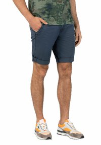 Navy blue shorts with rolled cuffs, made of soft fabric. Features side pockets and a relaxed fit, paired with multicolored sneakers.