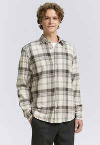 Geverifieerd shirt in room- en bruintinten, met knoopsluiting, lange mouwen, zachte stof en grote ruitpatronen door het hele shirt.