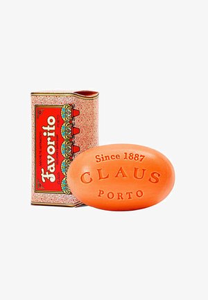 Ovales orangenes Stück Seife, geprägt mit "Claus Porto Seit 1887", neben roter und gemusterter rechteckiger Schachtel mit der Aufschrift "Favorito Red Poppy Bath Soap".