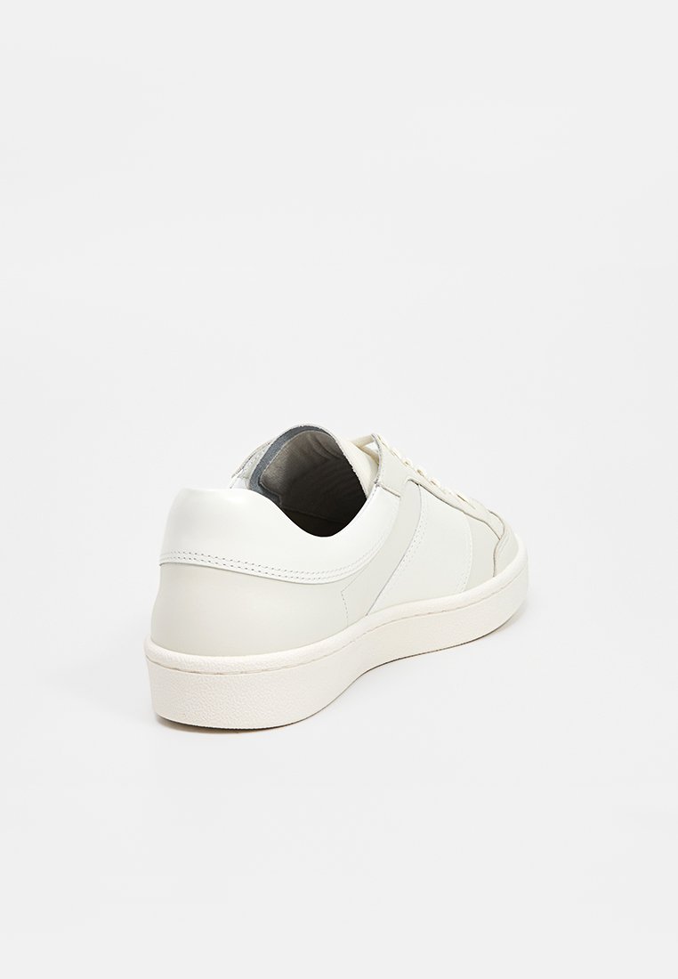 Witte leren sneaker met een gladde afwerking, ronde neus en een gecushionde zool. Beschikt over tonale stiksels en een laag uitgesneden ontwerp voor gemakkelijk dragen.