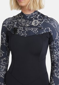 Wetsuit featuring a navy base with floral pattern on the shoulders, made of stretchy material, with a high neckline and front zipper detail.