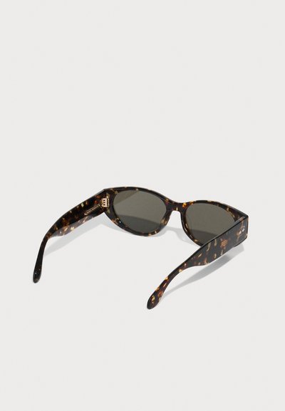 Ochelari de soare cu model țestoasă, cu lentile întunecate, o formă elegantă și unghiulară, și brațe subțiri cu detalii subtile din metal.