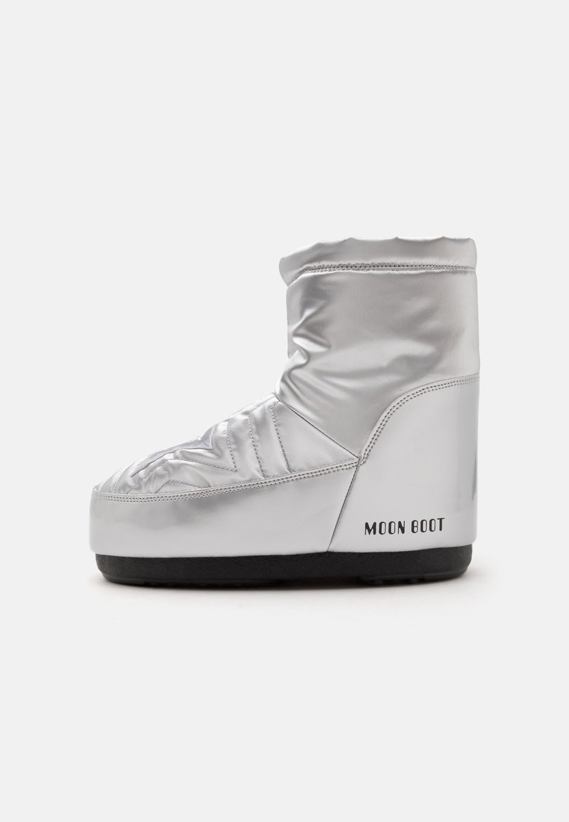 Moon Boot isolé argenté avec semelle noire, hauteur mi-mollet et design matelassé rembourré.