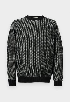 Maglione lavorato a maglia in bianco e nero con scollatura a girocollo, caratterizzato da un motivo testurizzato, polsini a costine e una vestibilità rilassata.