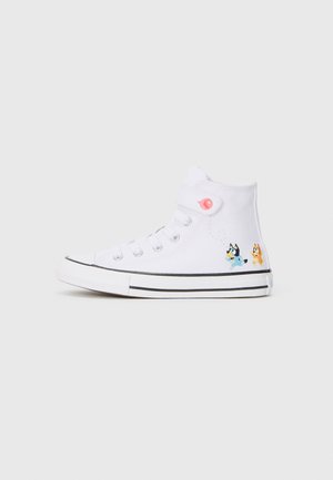 Sneaker alte bianche con strisce nere, caratterizzate da vivaci design di personaggi dei cartoni sui lati e un accento di bottone rosa.
