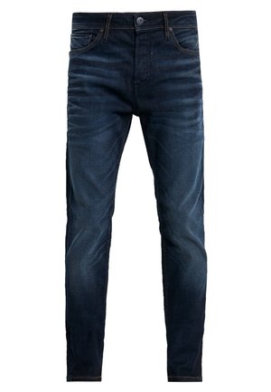 Jean en denim bleu foncé slim fit avec poches avant, fermeture à bouton et détails de décoloration subtils sur les cuisses et les genoux.
