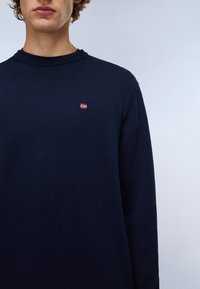 Navyblauwe lange mouwen trui in ribbelstructuur met een ronde hals en een klein geborduurd Noors vlaggetje op de borst.
