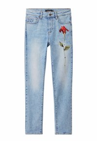 Vaalean siniset farkut, jotka ovat istuvuutta korostavat. Vasemmassa lahkeessa on kukkakirjonta, jossa on punainen ruusu ja vihreitä lehtiä.