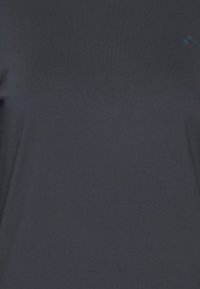 Dunkelgraues kurzärmeliges Shirt aus glattem Stoff, mit einem dezenten Logo auf der oberen rechten Seite in Blau. Einfaches, minimalistisches Design.