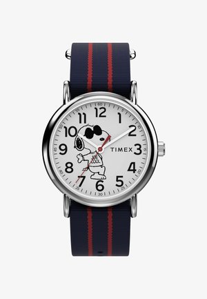 Montre Timex avec un cadran blanc, des chiffres noirs, une aiguille des secondes rouge et un graphique de Snoopy. Bracelet bleu marine avec des rayures rouges, boîtier en métal.