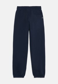 Marineblauwe joggingsbroek van zacht materiaal, met een elastische tailleband, taps toelopende benen en een klein zijzakje met een labeldetail.