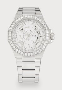 Relógio octogonal prateado da Guess com mostrador branco, três submostradores e acentos de cristal no bisel e nos marcadores de horas. Bracelete de metal.