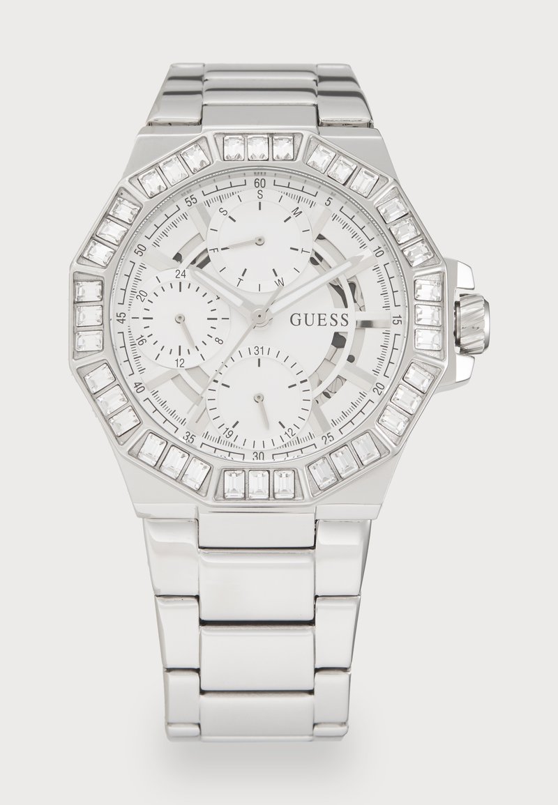 Relógio octogonal prateado da Guess com mostrador branco, três submostradores e acentos de cristal no bisel e nos marcadores de horas. Bracelete de metal.