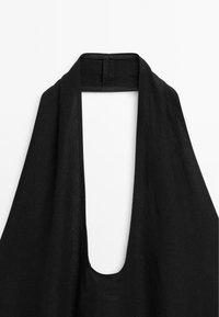 Schwarzes Trägershirt mit tiefem V-Ausschnitt und offenem Rückendesign; aus einem weichen, leichten Stoff mit glatter Textur gefertigt.