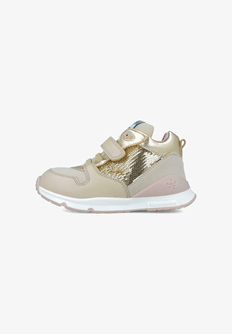 Zapatillas altas beige con acentos de lentejuelas doradas, correa de velcro y suela acolchada. Presentan una combinación de materiales lisos y texturizados.