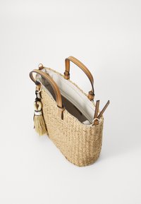 Borsa in paglia intrecciata con manici in pelle marrone e un pon-pon decorativo. Presenta un'apertura superiore e un interno foderato con dettagli di cucitura.