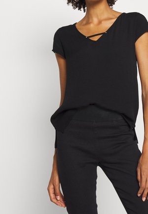 Czarna bluzka z krótkim rękawem, dekoltem w kształcie litery V i ozdobnym krzyżującym się paskiem przy szyi. Gładka tkanina, lekko luźny krój oraz boczne rozcięcia.