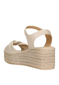 Beige kožené sandály na wedge podpatku s twistingovým předním designem, nastavitelným zadním páskem a tkanou jute podrážkou s texturovaným povrchem.